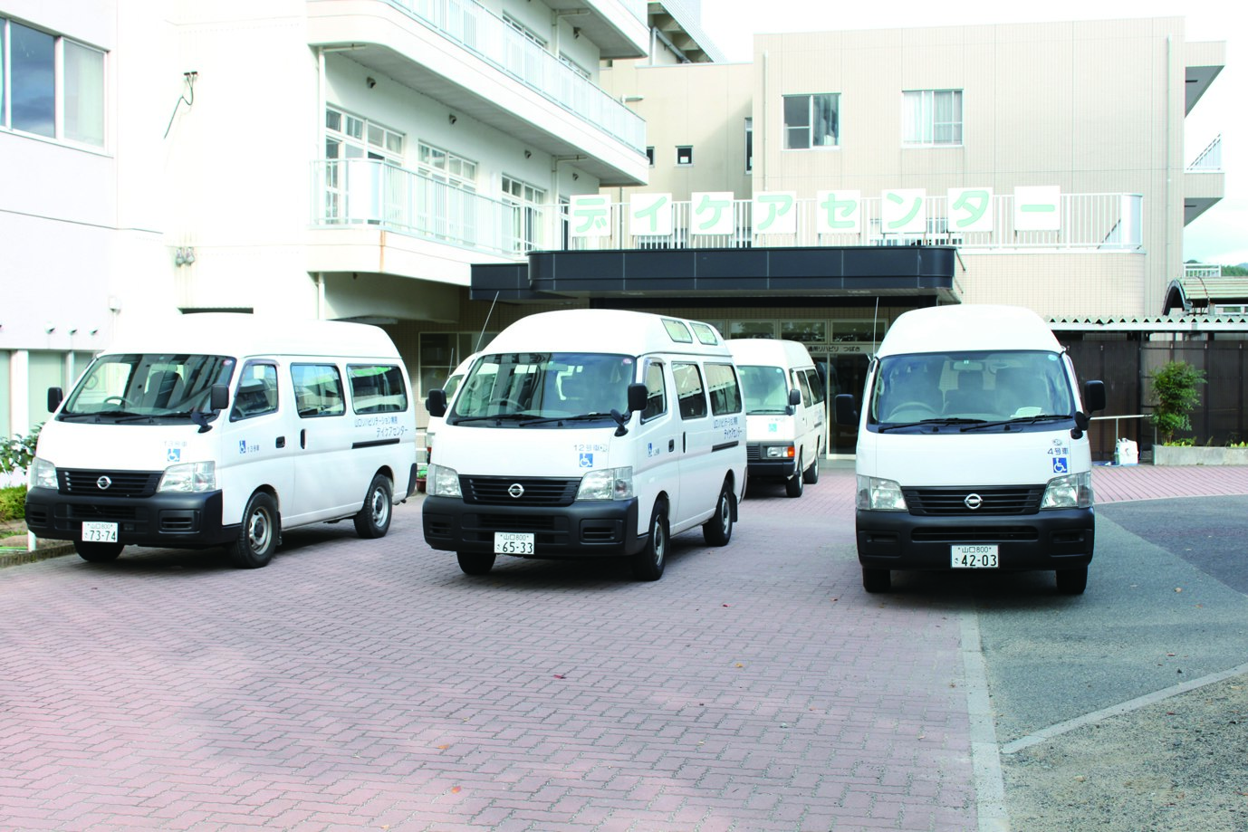 通所リハビリセンターの建物と送迎車