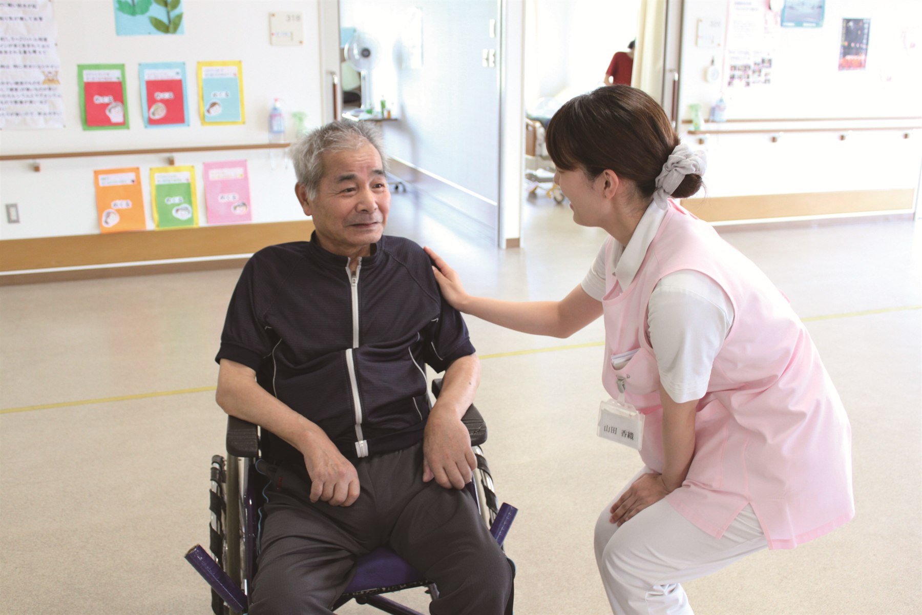 車椅子の患者様に寄り添うスタッフ